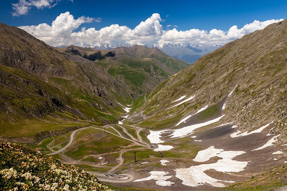 The narrow unpaved Abano Pass clinging to a steep mountainside on the way to Tusheti, Georgia