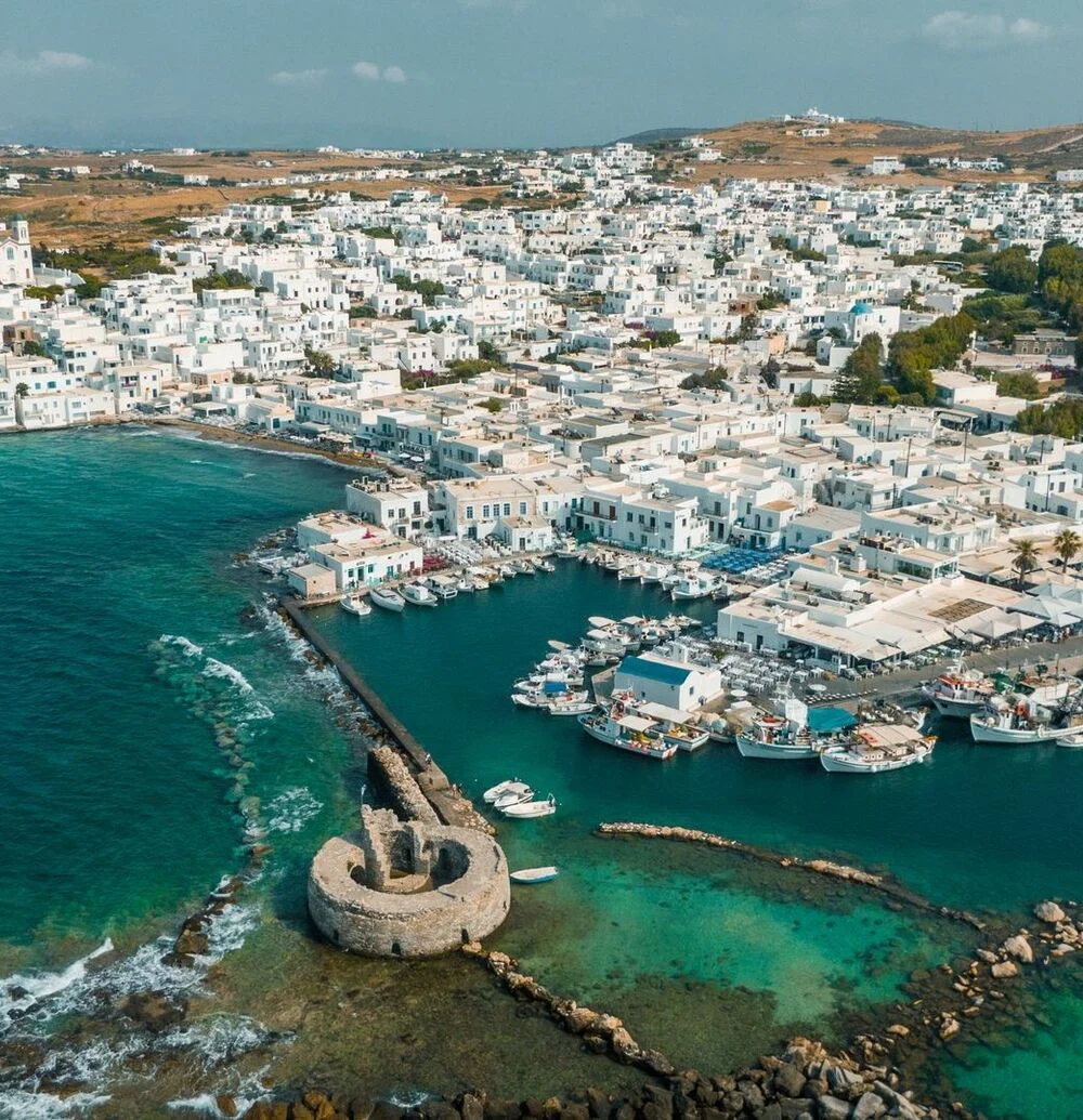 The fishing harbour of Naoussa on Paros with white houses and blue boats