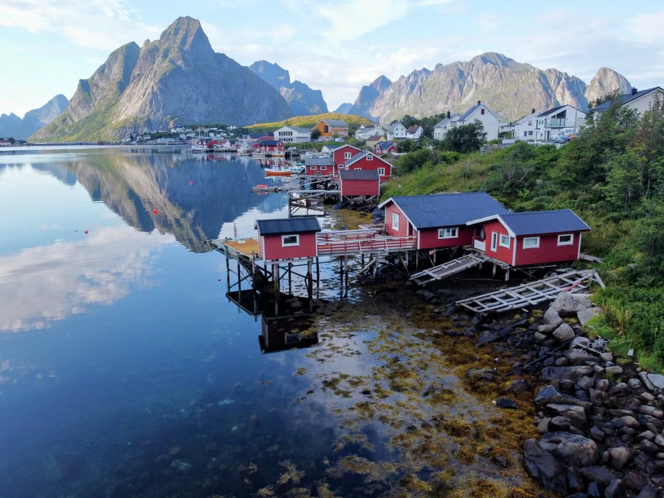 Red fishing cabins at Reine in Lofoten below sharp peaks