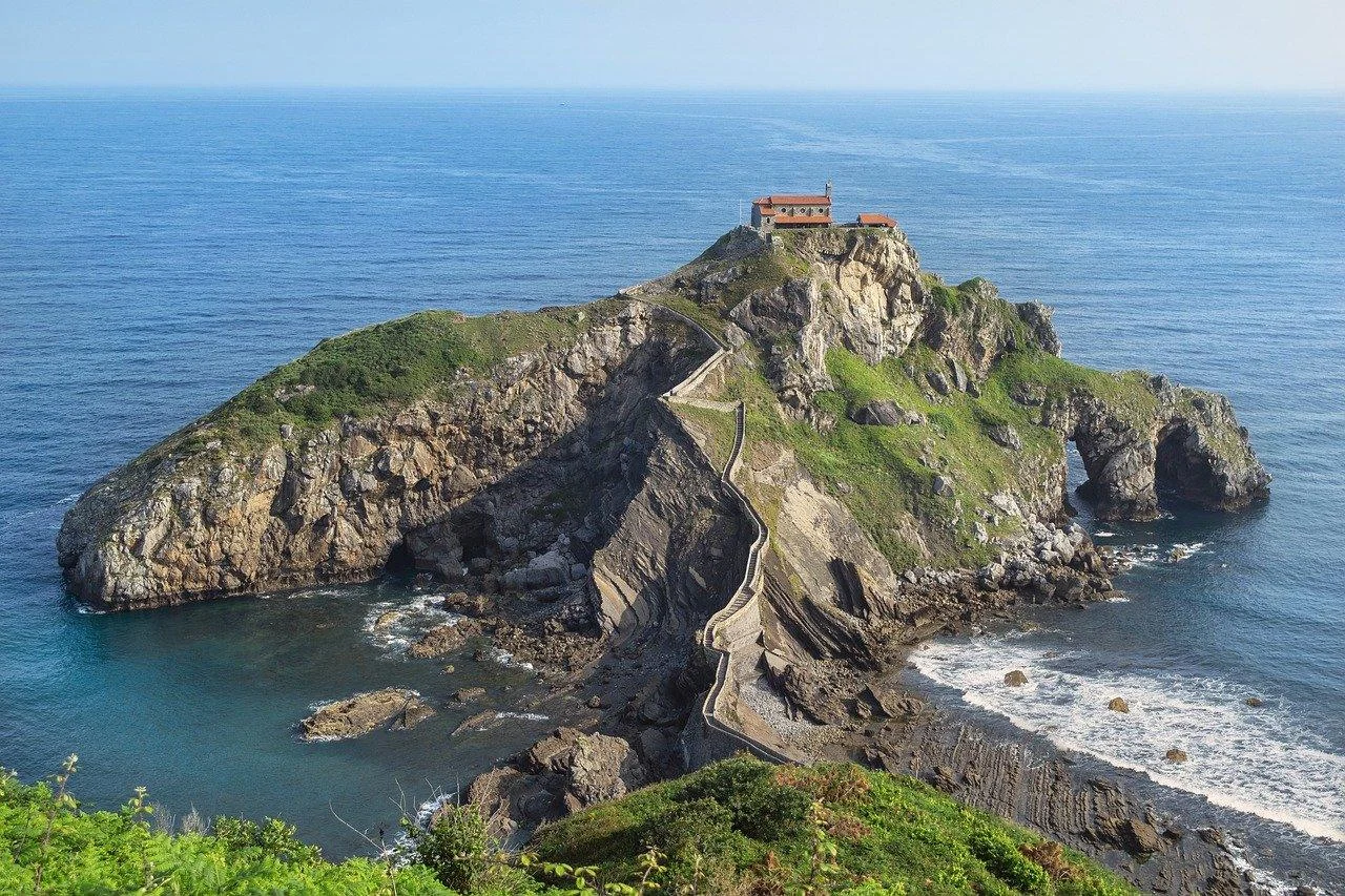 The green Basque coastline with cliffs and a fishing harbour on the Bay of Biscay