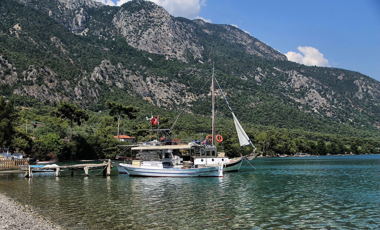 Boats moored in a calm cove below the mountains on the north shore of the Gökova gulf